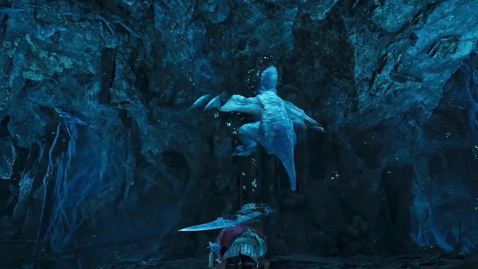 Khezu clinging to a blue cave wall above a hunter in Monster Hunter Wilds Ascendance, its pale body flattened against the rock