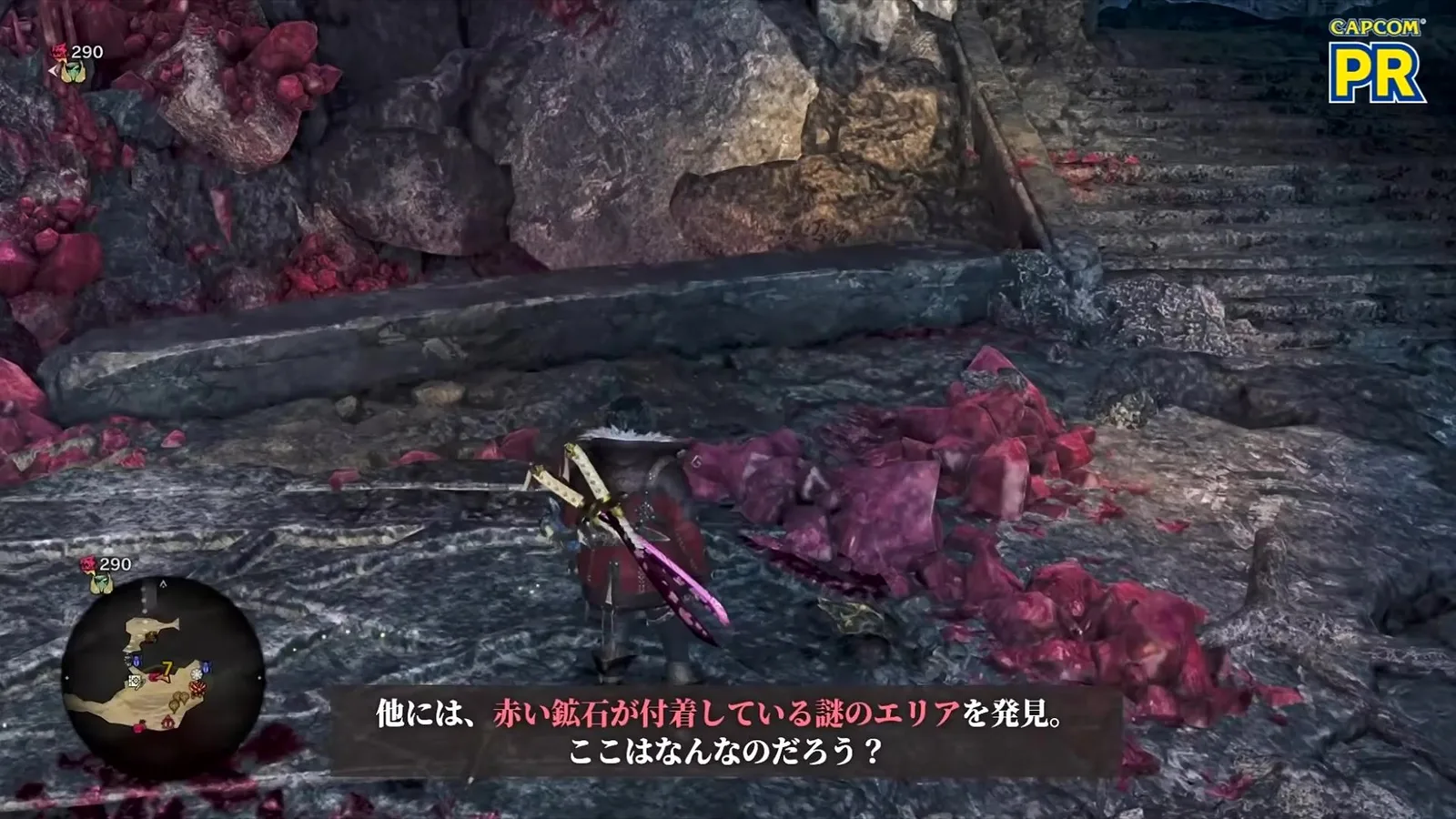 A hunter beside heaps of red ore crystals by stone stairs in Monster Hunter Wilds Ascendance preview footage, with a Japanese caption about a mysterious area